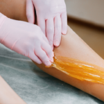 Sugaring hårfjerning på ben hvor sukkerpasta fjernes med hårets groretning